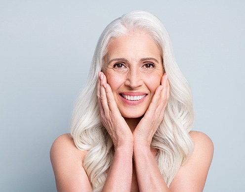 A gray-haired lady enjoying her new dental implants