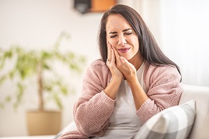 A woman suffering mouth pain after a dental implant surgery