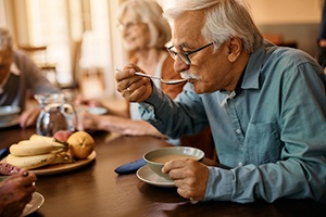 A senior eating soup at a residential care home